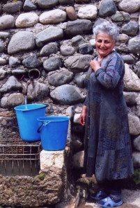 Woman fills buckets of water in the village of Dogh. (Photo: Tom Vartabedian)