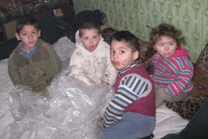 Children living in deplorable, conditions playing with bubble wrap