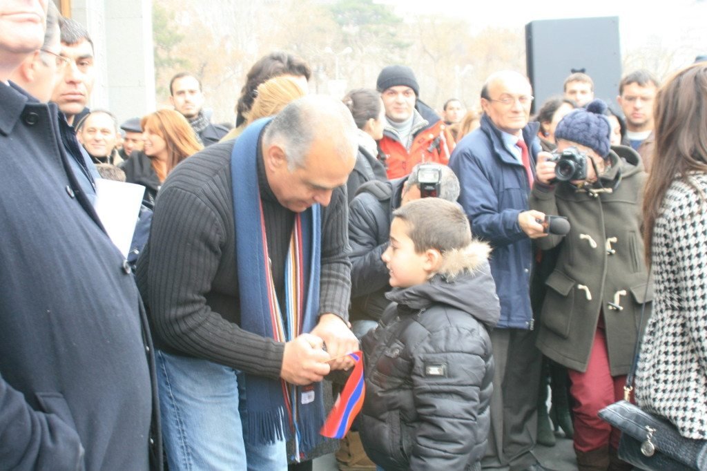 Aha yeghpayr kez mi trosh: A child gives Raffi Hovannisian the Armenian flag at Freedom Square in Yerevan on Feb. 22. (Photo by Khatchig Mouradian, The Armenian Weekly)