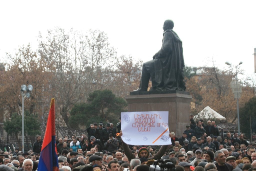 An activist on Freedom Square holds a sign condemning election fraud. (Photo by Khatchig Mouradian, The Armenian Weekly)