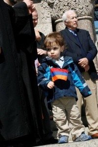 Two-year-old Hovig Baljian waves his tricolor while standing with his dad, Rev. Fr. Stephan Baljian, pastor, St. Gregory Armenian Church of Merrimack Valley. (Photo: Tom Vartabedian)