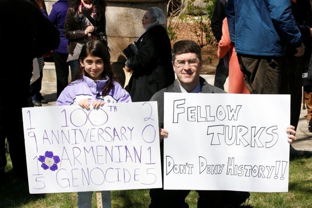 Eight-year-old Ani Eskanderian greets Mehmed Ali, a Turkish dissident, with their respective signs calling for recognition. (Photo: Tom Vartabedian)