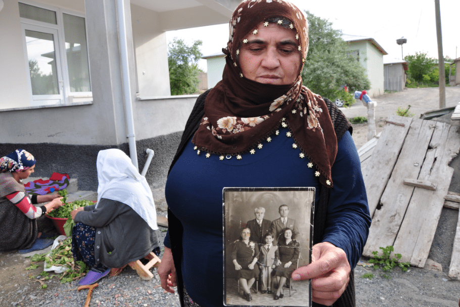 Woman holding a photo of lost relatives in Sakrat
