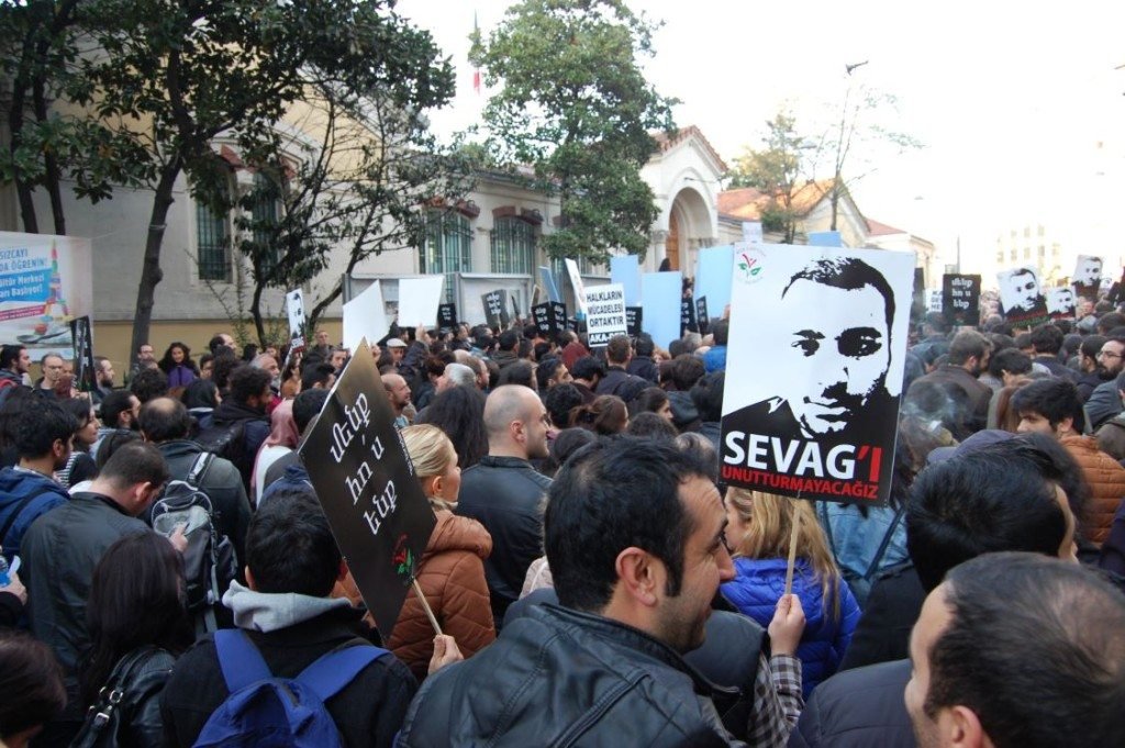 A demonstrator holds a poster of Sevag's face and the words, 'Sevag, we won’t forget you.' (Photo: Elsa Landard)