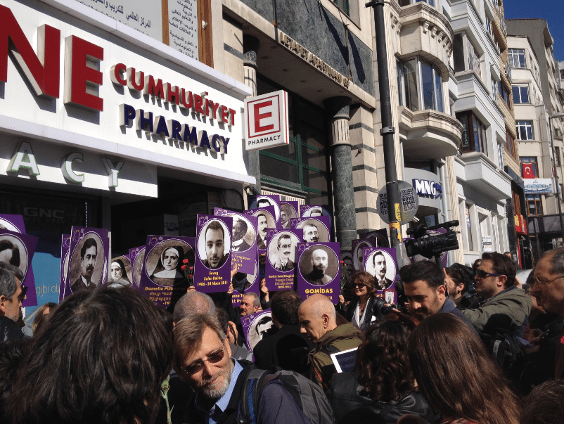 Outside of the former home of Komitas Vartabed, demonstrators hold portraits of the intellectuals arrested on April 24, 1915, as well as portraits of Hrant Dink and Sevag Balıkçı.