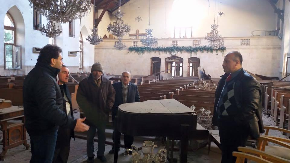 Rev. Selimian and community members assess the damage to the church