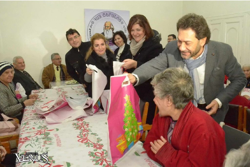 Rev. Haroutune Selimian distributes gifts to the elderly of the Old People's Home in Aleppo.
