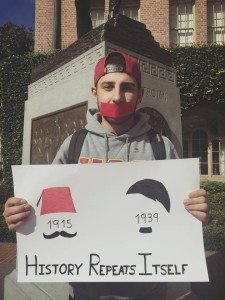 A student at the University of California holds a sign that reads 'History Repeats itself: 1915-1939)