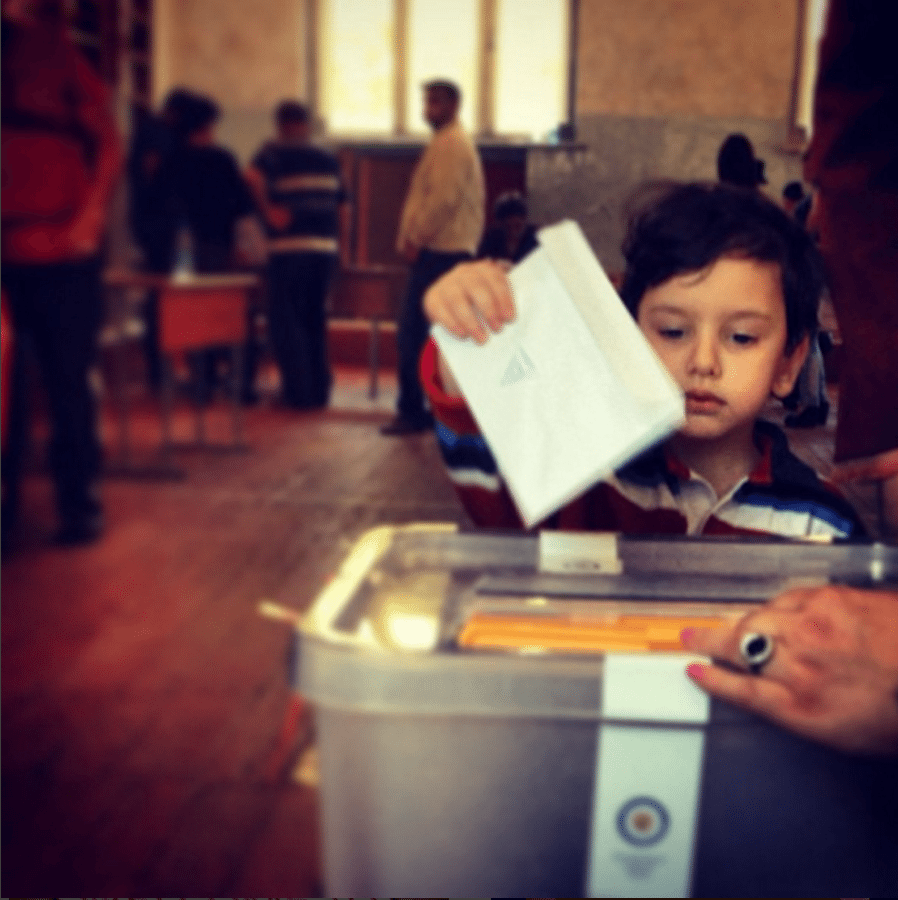 A young boy casts his grandmother's ballot in the 2013 Yerevan Municipal Elections (Photo: Rupen Janbazian)