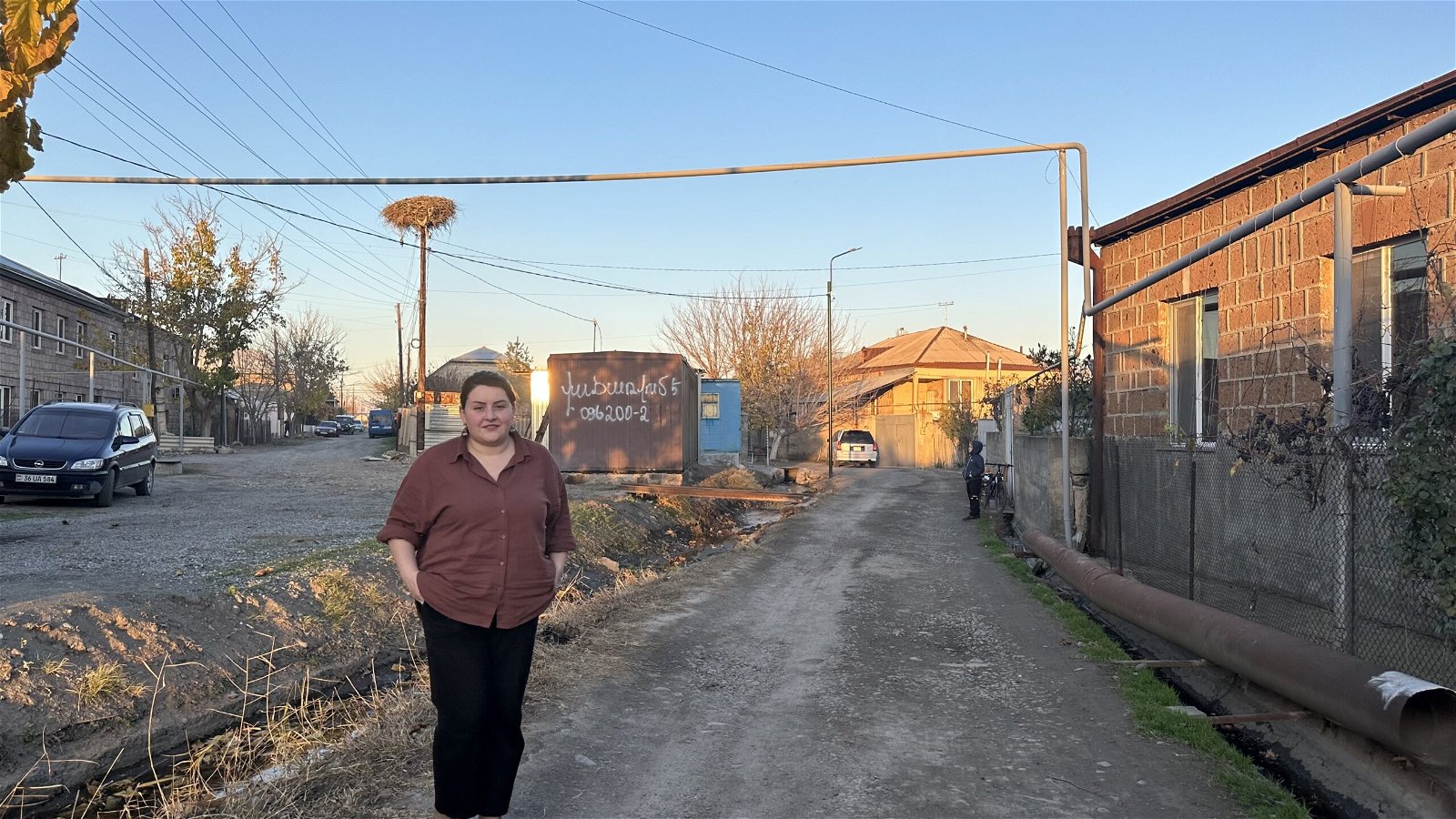 https://armenianweekly.b-cdn.net/wp-content/uploads/2024/01/Lilit-Sargsyan-in-front-of-the-makeshift-house-or-domik-which-she-bought-with-the-help-of-friends-and-will-become-her-new-house-scaled.jpeg